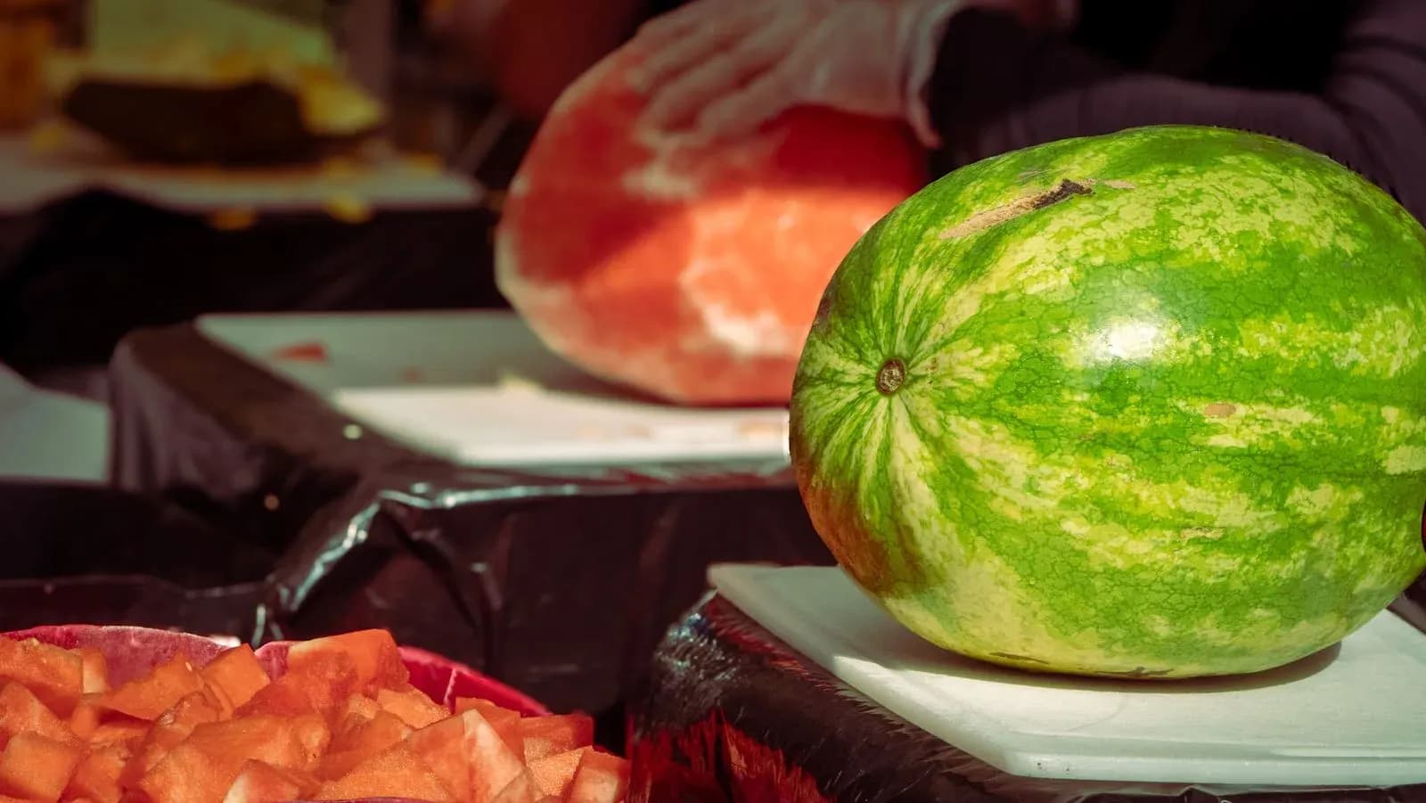 Целый и нарезанный арбуз на разделочных досках